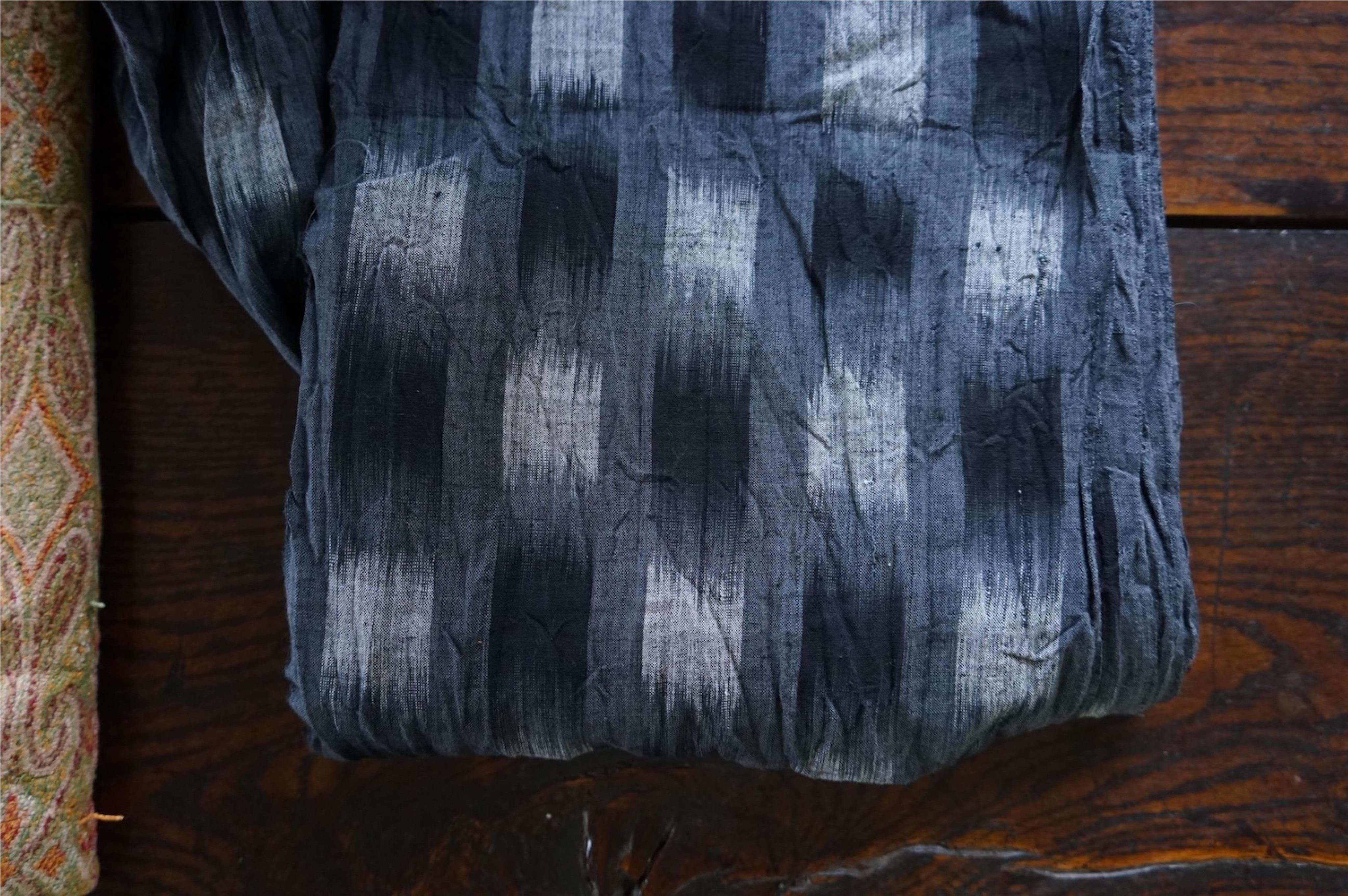 A long narrow length of grey Ikat woven fabric, a roll of Indian mirrored edging, a geometric batik printed length and a woven paisley ‘style’ tasselled stole. (4). Batik 392cm long x 108cm wide., Condition - good, all a
